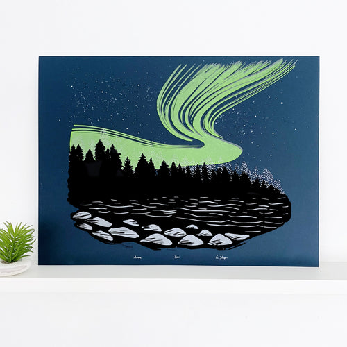 Northern lights artwork. A rich neon green aurora ink on top of a dark blue backround behind the shadows of a Black Forest. A lake in the foreground showing some light on rocks.  Aurora Borealis front